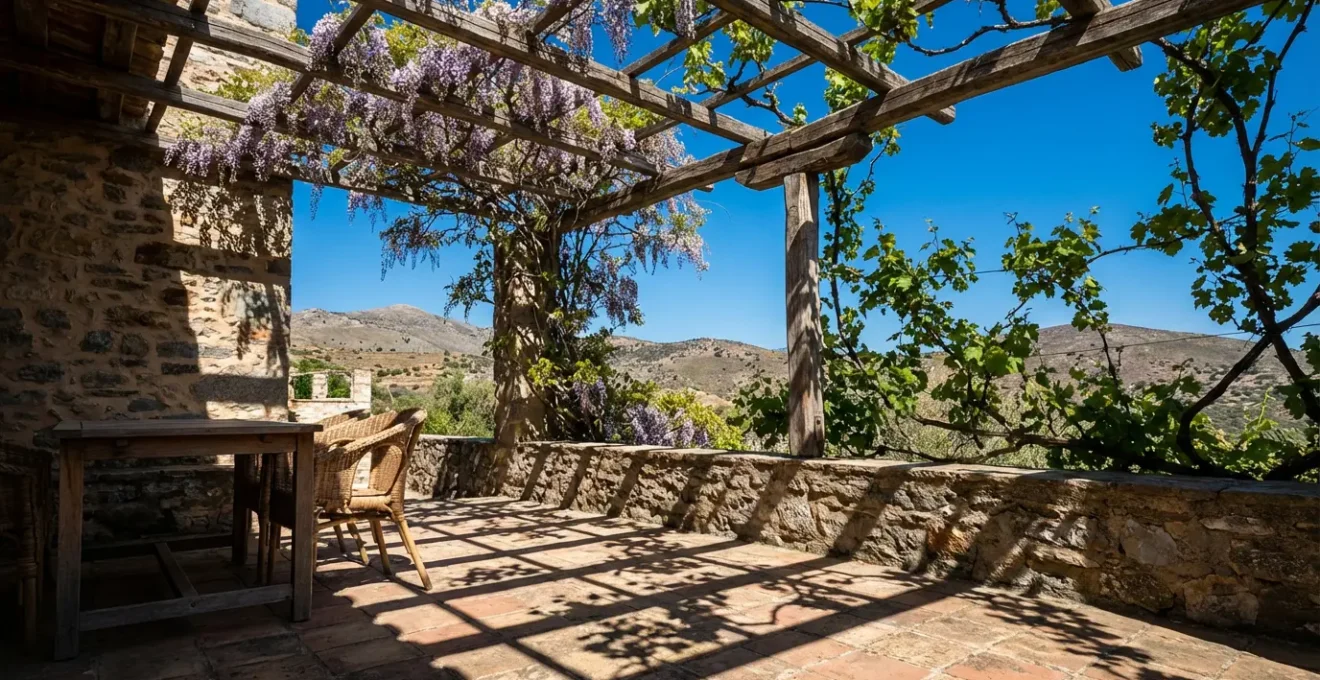 Terraza mediterránea con pérgola de madera, plantas trepadoras y zona de estar bajo sombra natural